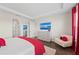 Spacious main bedroom featuring a bed with red accents, large dresser with television, and natural light at 4430 Pond Brook Ct, Bradenton, FL 34211