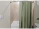 Shower and tub combination with neutral tiling and a modern shower curtain at 4430 Pond Brook Ct, Bradenton, FL 34211