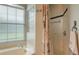 Bathroom showcasing a shower with decorative tile, towel rack, and a large window for natural light at 4612 4Th E Ave, Bradenton, FL 34208