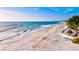 Expansive sandy beach with clear blue waters, beach chairs, and a tiki hut for relaxation at 4612 4Th E Ave, Bradenton, FL 34208