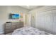 Bright bedroom featuring a comfortable bed, dresser with television, and a closet for storage at 4612 4Th E Ave, Bradenton, FL 34208