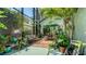 Relaxing screened patio with a seating area surrounded by lush tropical plants and brick and painted flooring at 4612 4Th E Ave, Bradenton, FL 34208