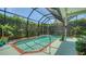 Screened-in pool area, featuring a small pool and surrounding greenery, creating a private outdoor space at 4612 4Th E Ave, Bradenton, FL 34208