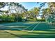 Outdoor tennis court surrounded by lush greenery and mature trees at 4612 4Th E Ave, Bradenton, FL 34208