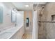 Bathroom features a shower with gray tiling, white cabinets, and double sinks at 4629 Whirlaway Dr # B, Sarasota, FL 34233