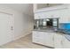 Bright kitchen featuring granite countertops, white cabinets, and open layout at 4629 Whirlaway Dr # B, Sarasota, FL 34233