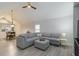 Bright living room features vaulted ceilings, a ceiling fan, and a comfortable gray sectional with matching ottoman at 4629 Whirlaway Dr # B, Sarasota, FL 34233