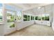 Bright sunroom featuring tile floors, multiple windows, and decorative front door at 4629 Whirlaway Dr # B, Sarasota, FL 34233