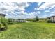 Lush backyard with green grass, a black fence, and a scenic view of a tranquil lake at 4971 Oyster Pearl St, Bradenton, FL 34211
