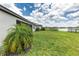 Spacious backyard with a palm tree, lake view, and well-maintained lawn at 4971 Oyster Pearl St, Bradenton, FL 34211