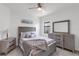 Well-lit bedroom with striped bedding, soft throw blanket, and a weathered wood furniture set at 4971 Oyster Pearl St, Bradenton, FL 34211