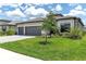 Charming home boasts a three-car garage, stone accents, tile roof, lush landscaping, and a brick paver driveway at 4971 Oyster Pearl St, Bradenton, FL 34211