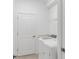 Functional laundry room with a side-by-side washer and dryer, storage shelf, and white door at 4971 Oyster Pearl St, Bradenton, FL 34211