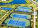 Aerial view of community tennis and basketball courts surrounded by lush landscaping and scenic water views at 4971 Oyster Pearl St, Bradenton, FL 34211