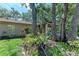 The backyard features a view of the home with lush landscaping and mature trees at 5109 28Th W St, Bradenton, FL 34207