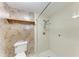 Full bathroom with white tiled shower and toilet with overhead wooden shelf at 5109 28Th W St, Bradenton, FL 34207