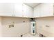 A laundry room with white cabinets, utility sink, and hot water heater for added convenience at 5109 28Th W St, Bradenton, FL 34207