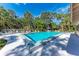 Community pool surrounded by lounge chairs, trees, and blue skies at 5109 28Th W St, Bradenton, FL 34207