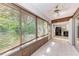 Bright sunroom with tiled flooring, wood paneled siding, and large windows overlooking greenery at 5109 28Th W St, Bradenton, FL 34207