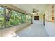 An empty sunroom with large windows and a ceiling fan, perfect for enjoying the outdoor views at 5109 28Th W St, Bradenton, FL 34207