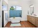 Bright bathroom with a freestanding tub, wood-look floors, and a modern vanity with double sinks at 5110 19Th W Ave, Bradenton, FL 34209