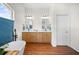 Bright bathroom with wood floors, dual vanity, bathtub, and a window with blue blinds at 5110 19Th W Ave, Bradenton, FL 34209