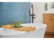 Close up of bathtub with matte black faucet, window with blue blind, and plant on shelf at 5110 19Th W Ave, Bradenton, FL 34209