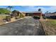 Spacious driveway leading to a single-story home, showcasing the front yard's mature landscaping at 5114 36Th Avenue W Dr, Bradenton, FL 34209