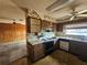 A kitchen with a window, wooden cabinets, and appliances is connected to a living area at 5114 36Th Avenue W Dr, Bradenton, FL 34209