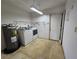 Functional laundry room with a washer, dryer, water heater and storage shelves at 5114 36Th Avenue W Dr, Bradenton, FL 34209