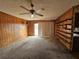 Living room features paneled walls, shelving, ceiling fan and sliding glass doors at 5114 36Th Avenue W Dr, Bradenton, FL 34209