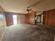 Large living room includes paneled walls, carpeting, ceiling fan, and access to the kitchen at 5114 36Th Avenue W Dr, Bradenton, FL 34209