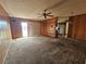 A living room includes paneled walls, carpeting, ceiling fan, shelving, and a sliding door at 5114 36Th Avenue W Dr, Bradenton, FL 34209