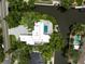 Aerial view of waterfront home showing expansive paver driveway, landscaping, pool, and dock at 512 Treasure Boat Way, Sarasota, FL 34242