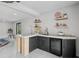 Chic bar featuring a sleek countertop, modern shelving, and a wine fridge, perfect for entertaining guests at 512 Treasure Boat Way, Sarasota, FL 34242