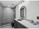 Bathroom featuring gray tiling, modern vanity with a black sink, and a glass-enclosed shower at 512 Treasure Boat Way, Sarasota, FL 34242