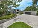 Elegant gray home featuring lush landscaping, a paver driveway, and a modern architectural design at 512 Treasure Boat Way, Sarasota, FL 34242