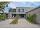 Modern home with a paved driveway, large windows, and landscaped entry under a blue sky at 512 Treasure Boat Way, Sarasota, FL 34242
