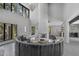 Spacious living room featuring high ceilings, large windows, a circular sofa, and a modern fireplace at 512 Treasure Boat Way, Sarasota, FL 34242