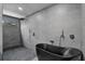 Modern shower with gray tiling, rainfall showerhead, and a black soaking tub at 512 Treasure Boat Way, Sarasota, FL 34242