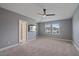 Primary bedroom with neutral carpet, ceiling fan, mounted tv, and natural light at 5191 78Th St E Cir, Bradenton, FL 34203