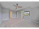 Primary bedroom with neutral carpet, ceiling fan, mounted television, and ensuite bathroom at 5191 78Th St E Cir, Bradenton, FL 34203