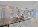 Open-concept kitchen island with stainless steel sink, pendant lighting, and stone countertops at 5191 78Th St E Cir, Bradenton, FL 34203