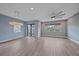Bright living room featuring wood-look tile flooring, modern lighting, and large windows at 5191 78Th St E Cir, Bradenton, FL 34203