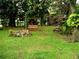 Serene backyard featuring a swing, rock formation, string lights, and mature trees creating a relaxing outdoor space at 5439 3Rd E St, Bradenton, FL 34203