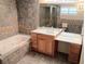 Well-lit bathroom with a jacuzzi tub, walk-in shower, vanity, and tile flooring, offering a luxurious and modern feel at 5439 3Rd E St, Bradenton, FL 34203
