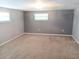 Carpeted bedroom with neutral walls and natural light from two windows, providing a peaceful and comfortable space at 5439 3Rd E St, Bradenton, FL 34203