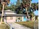 Charming single-Gathering home with a vibrant blue front door and beautiful tropical landscaping at 5439 3Rd E St, Bradenton, FL 34203
