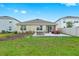 Backyard with a stone patio featuring outdoor furniture and a well maintained lawn at 5659 Woodland Sage Dr, Sarasota, FL 34238