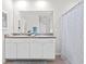 Bright bathroom with a double sink vanity, granite countertop, and shower with patterned curtain at 5659 Woodland Sage Dr, Sarasota, FL 34238
